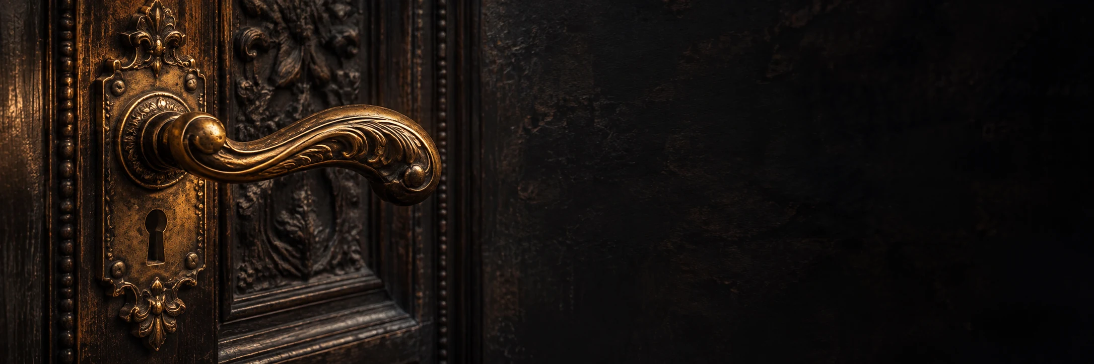 Poignée dorée ouvragée sur une porte ancienne