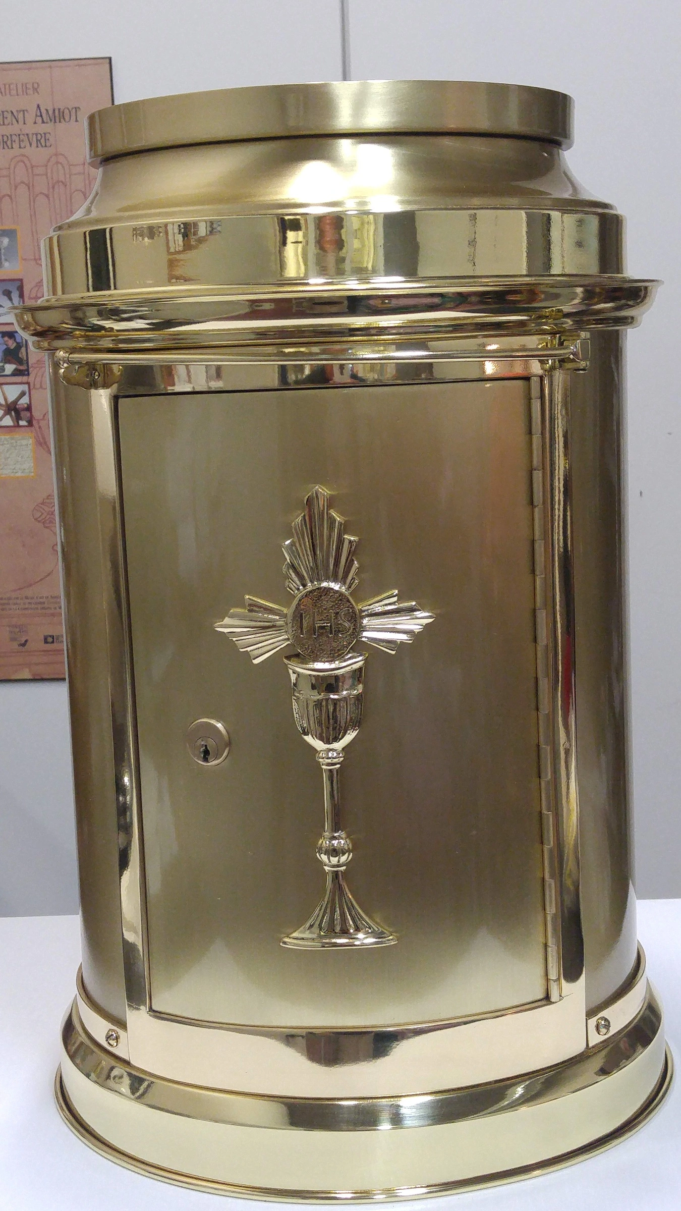 Tabernacle cylindrique brillant à porte ornée d’un calice, après restauration